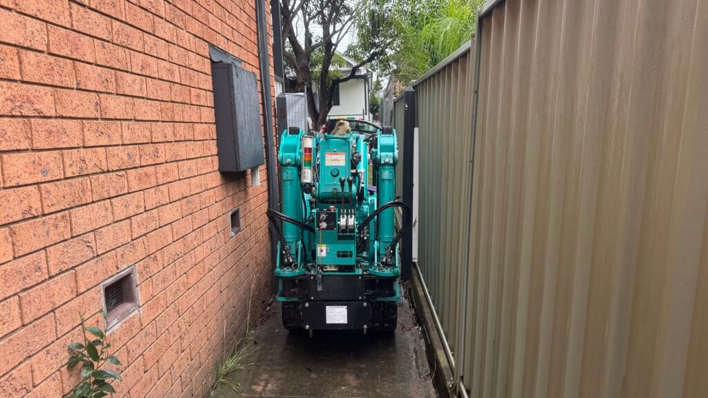 Maeda 285 mini crawler crane tracking down a very narrow side access beside a house
