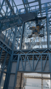 Glass Lifter hire Sydney - 305 mini crane lifting a glass panel inside a house.