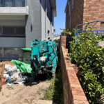 spider crane moving through narrow side access between houses