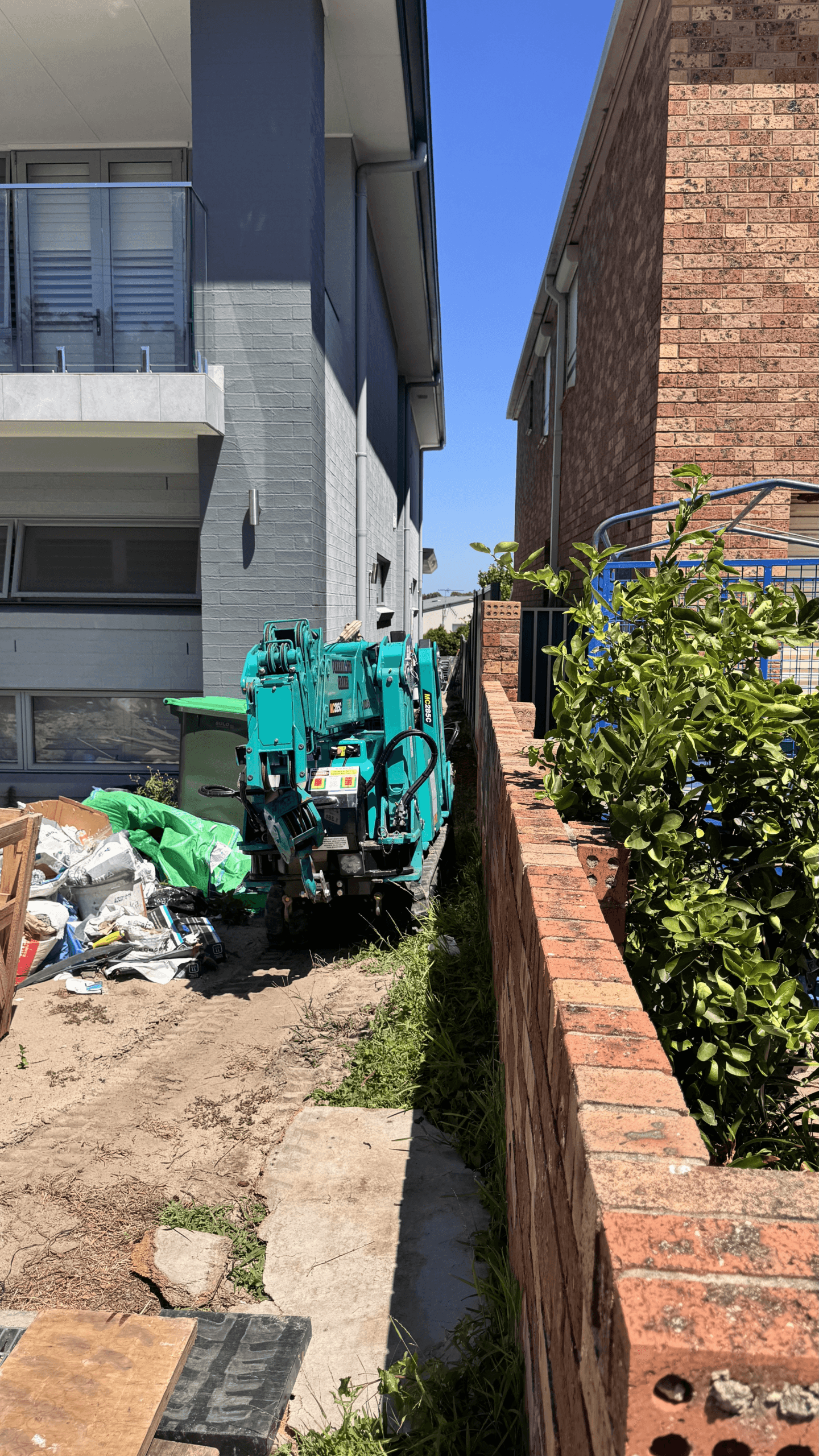 Crane hire Liverpool - Maeda spider crane moving down the narrow side of a house on a tight-access site
