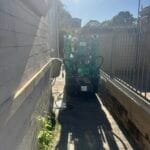 Maeda MC285 spider crane moving through narrow side access of house for steel beam installation in Sydney