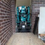 spider crane positioned inside tight access area after passing through doorway