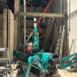 spider crane lifting structural beams inside house in tight access environment