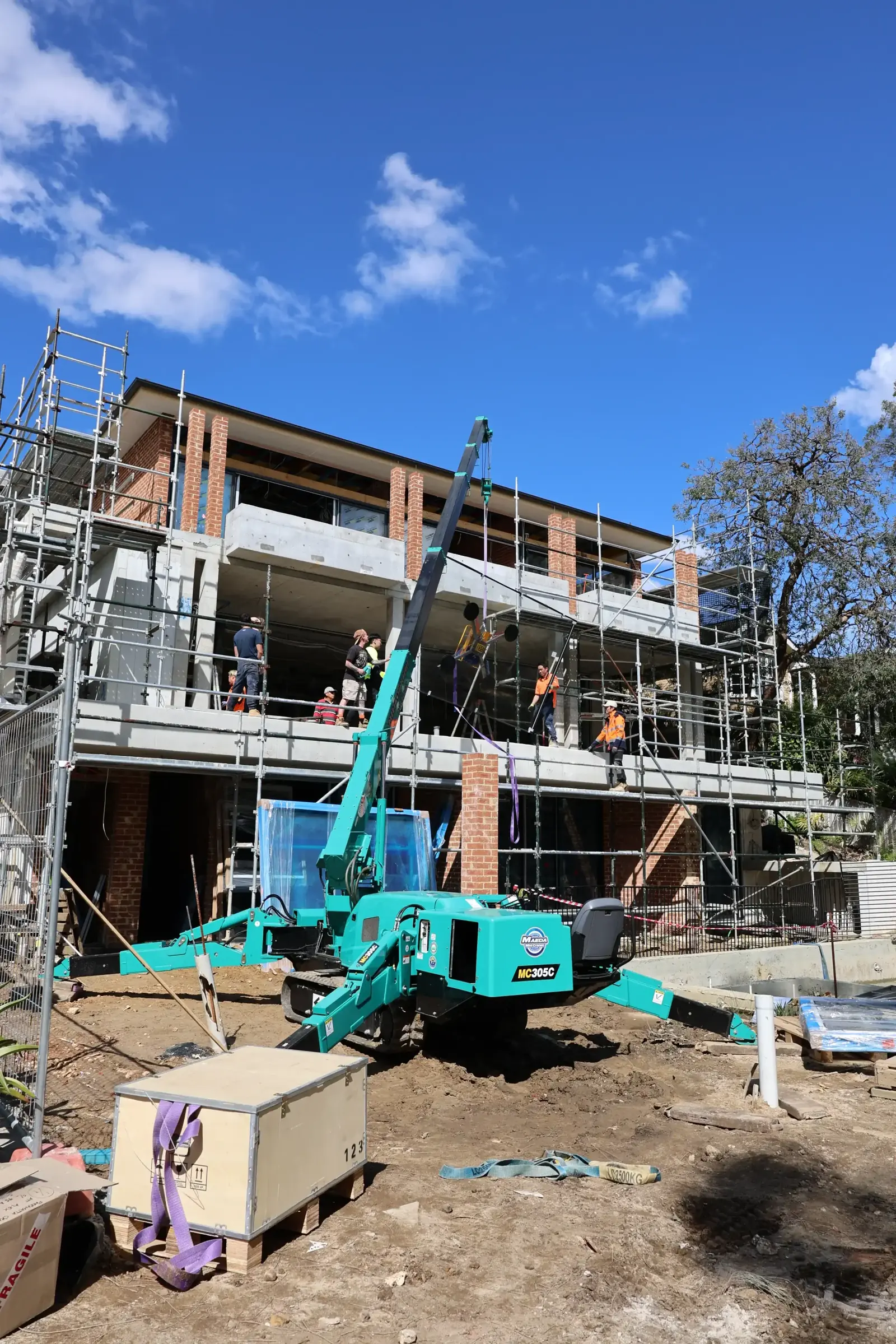 Maeda 305 spider crane lifting glass panels in Ryde
